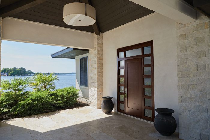 A shaded patio with a seaside view and an modular modern door