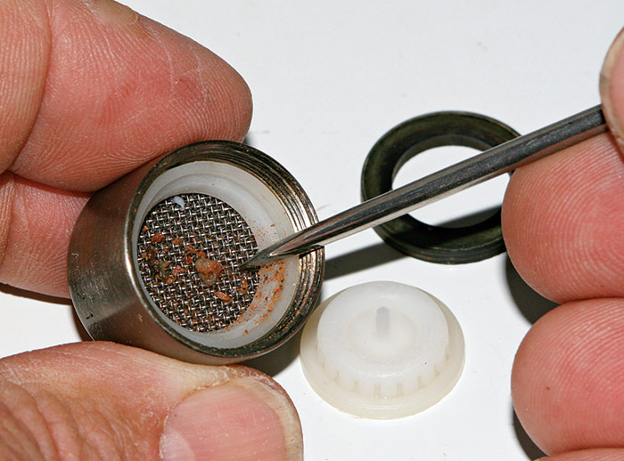 cleaning the holes with a toothpick, large sewing needle or other small, sharp tool