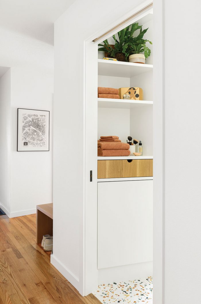An open closet with shelves for linens