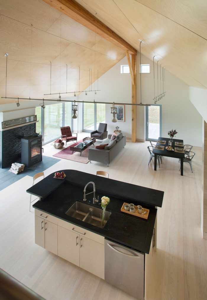 An open concept living room with a wood stove in the corner