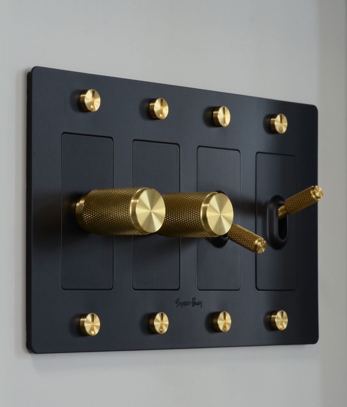 A black and gold light switch pannel with toggles and dimmers