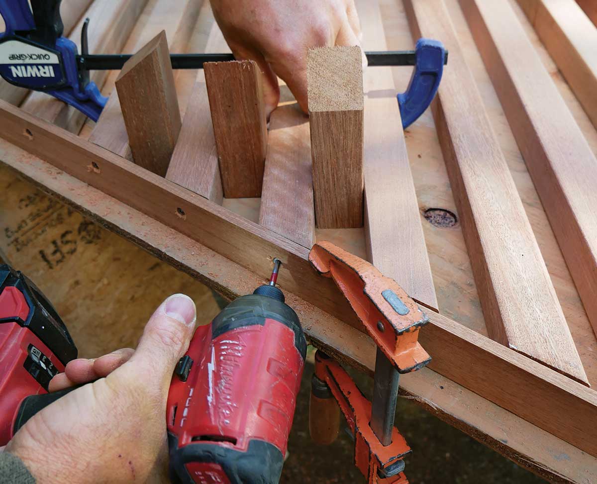 Add the bottom subrail. Use cutoffs and clamps to ensure proper spacing as you predrill for screws and fasten the balusters. One screw per baluster is sufficient. 