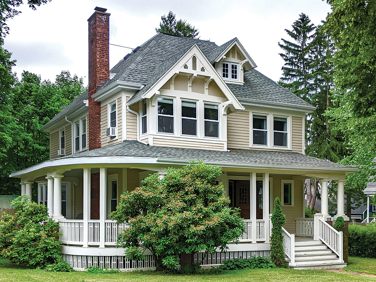 beige house with wraparound porch