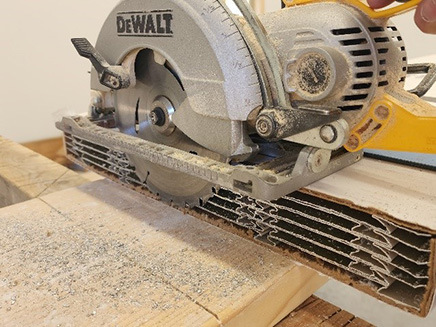Cutting the soffits with a circular saw while still in the cardboard packaging