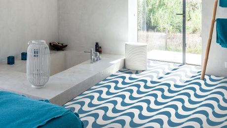 Curved blue cement tile in a bathroom next to a bathtub and window
