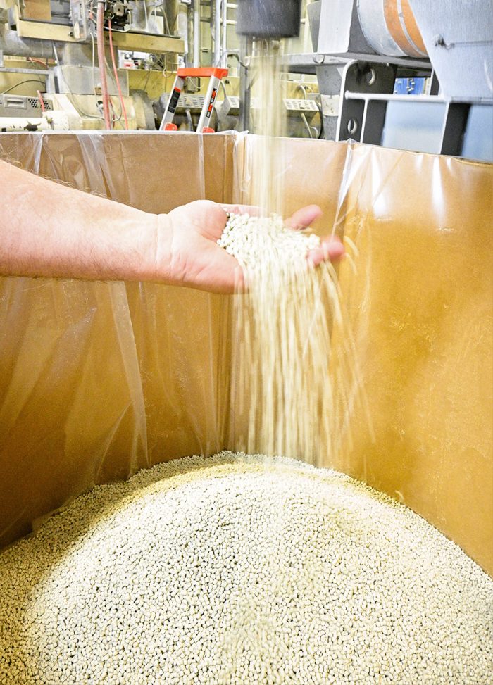 Beads of material falling through hands into a container