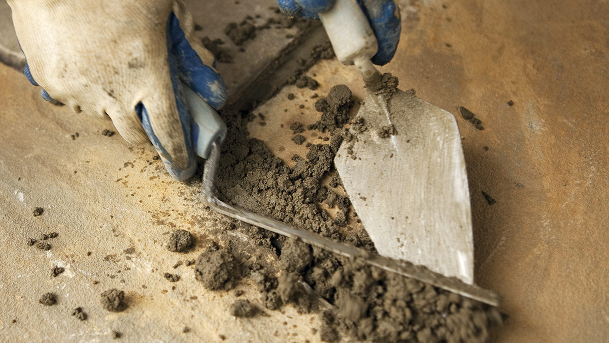 A Builder Is Laying Bricks With Cement And Trowel Using Masons