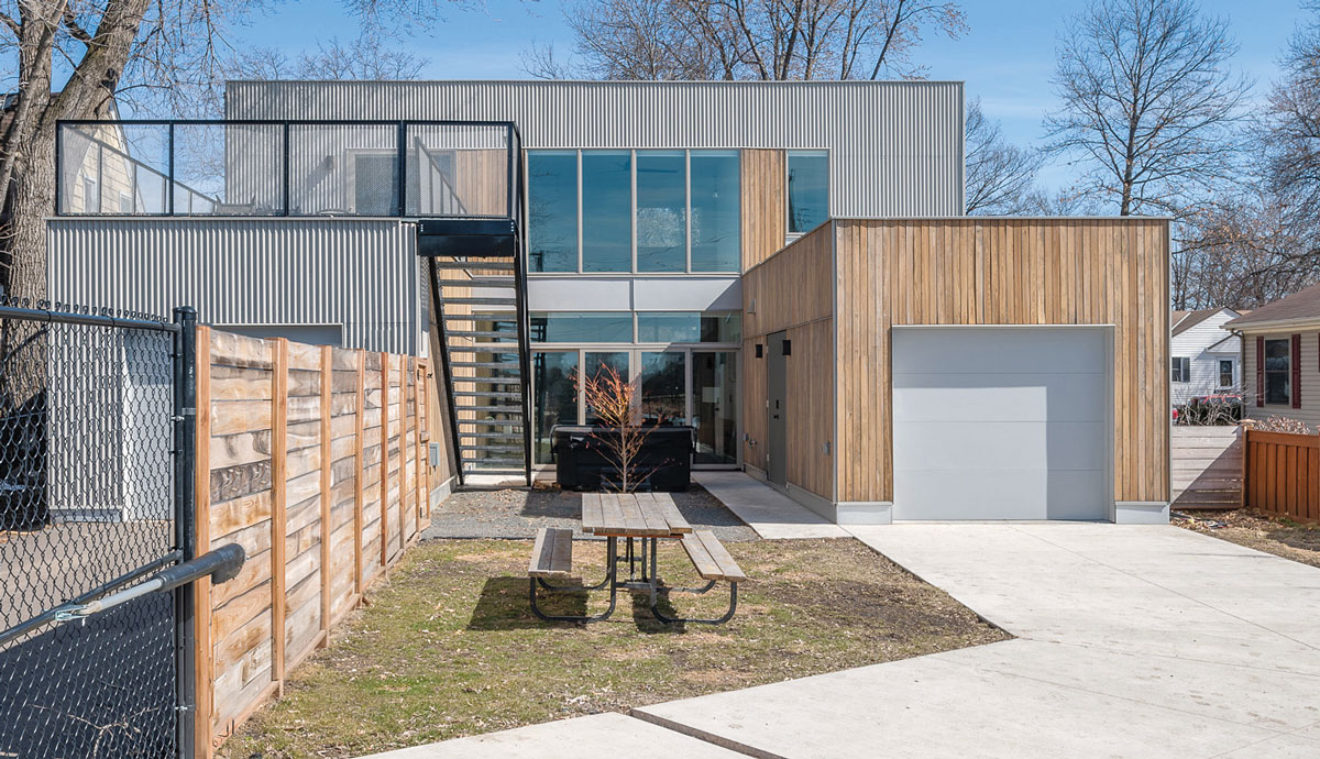 exterior of house with a garage, hot tub, picnic table, and eck