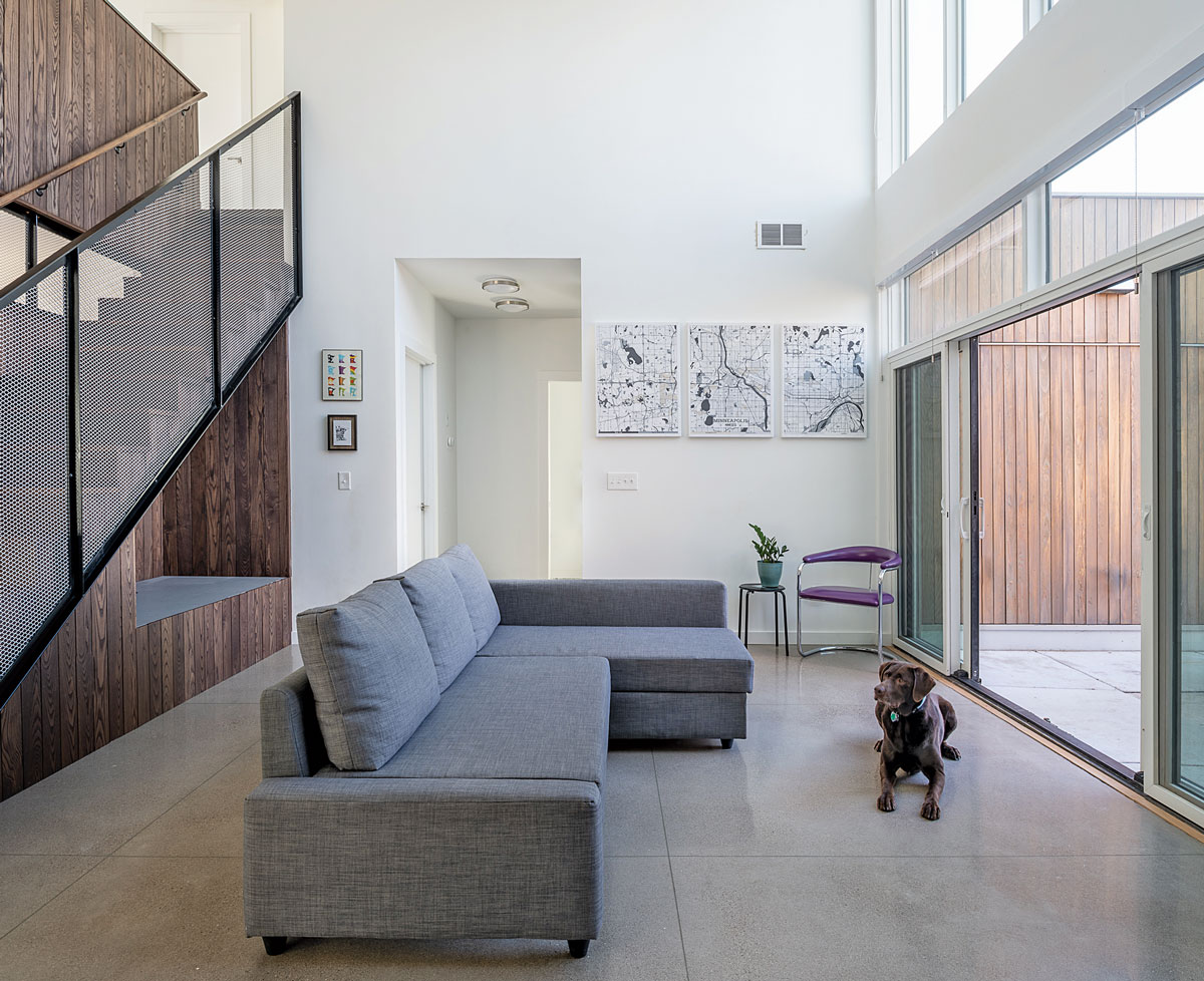 gray couch facing glass doors and brown dog sitting on floor
