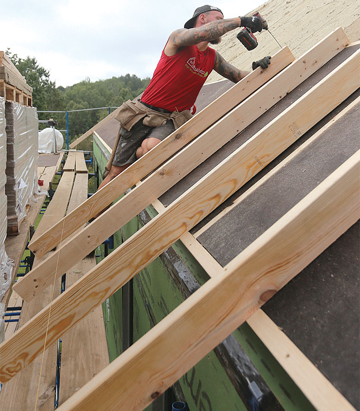 worker fastening overhangs on roof