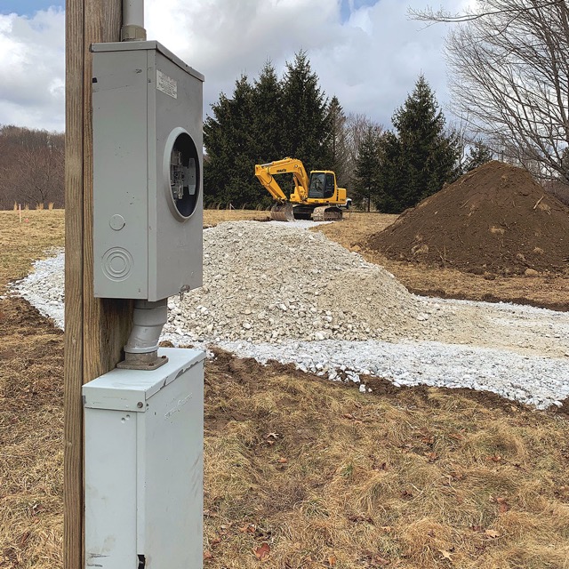 Photo of a temporary power set-up with an earth mover in the background.