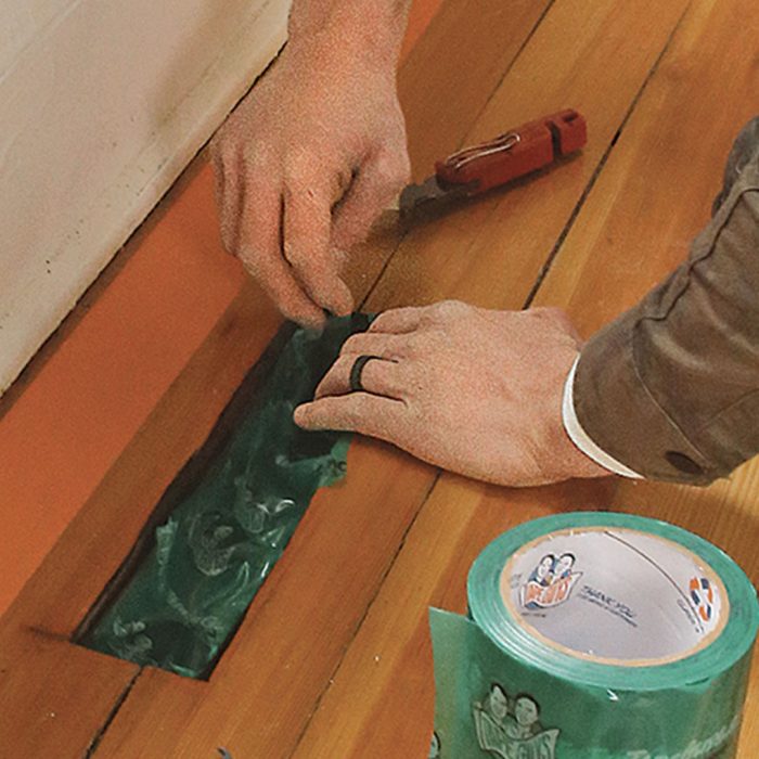 Photo of hands applying self-adhering plastic film to register.