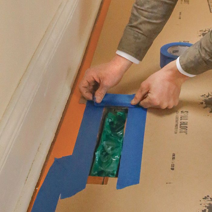 Photo of hands leaving masking-tape gap around the register.