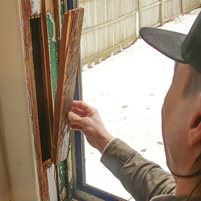 Photo of hands filling sash pockets with self-adhering film.