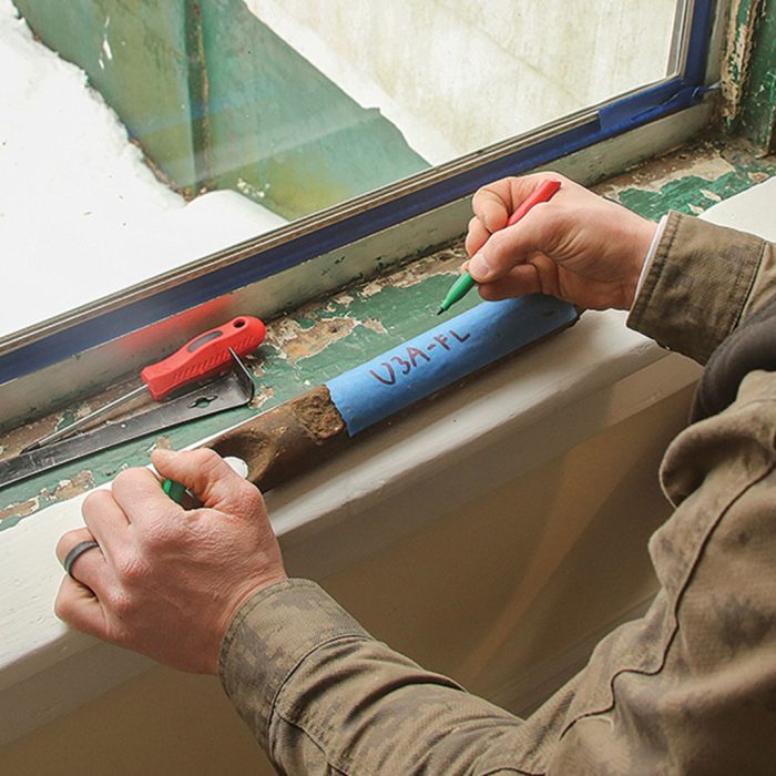 Photo of sash weights being labeled with sharpie and masking tape.