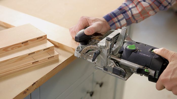 Photo of hands using a Festool Domino tool.