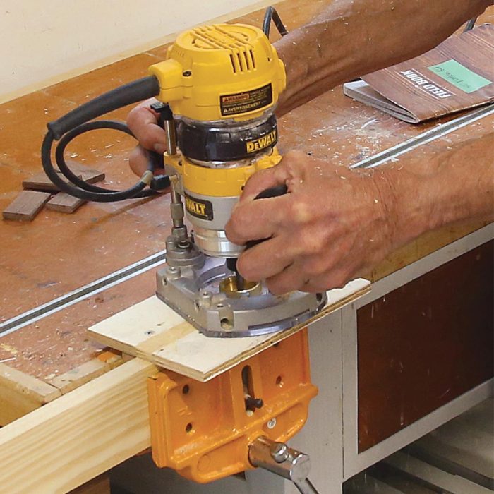 A photo of hands using a router to mortise the other side of the stile.