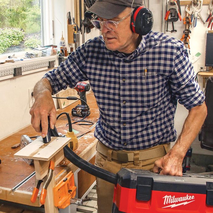 Photo of the author, Tim, cleaning the loose tenon jig with a shop vacuum.