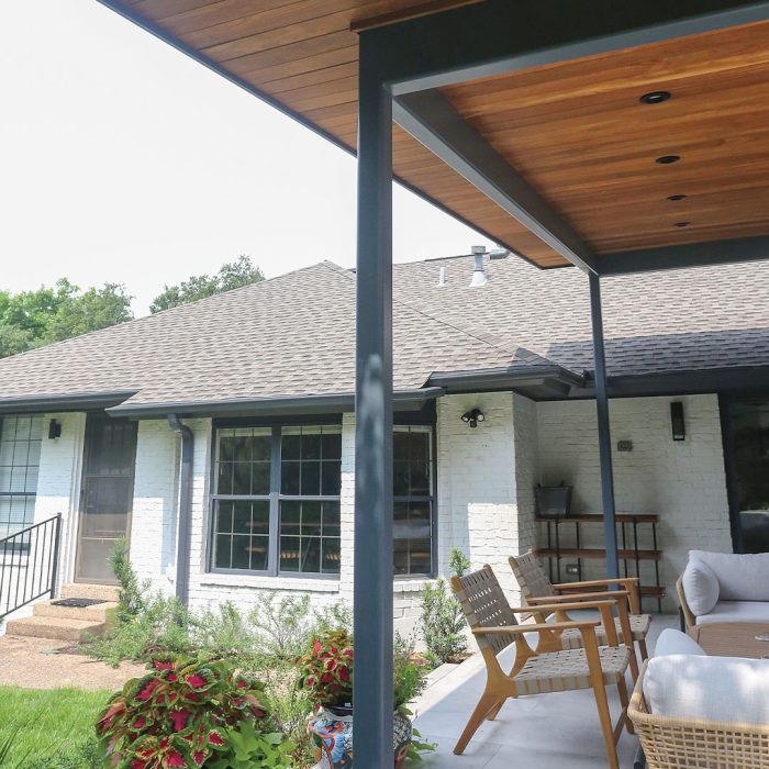 Photo of a white ranch-style home after renovation with an outdoor living space addition made of cumaru hardwood, metal, and more.