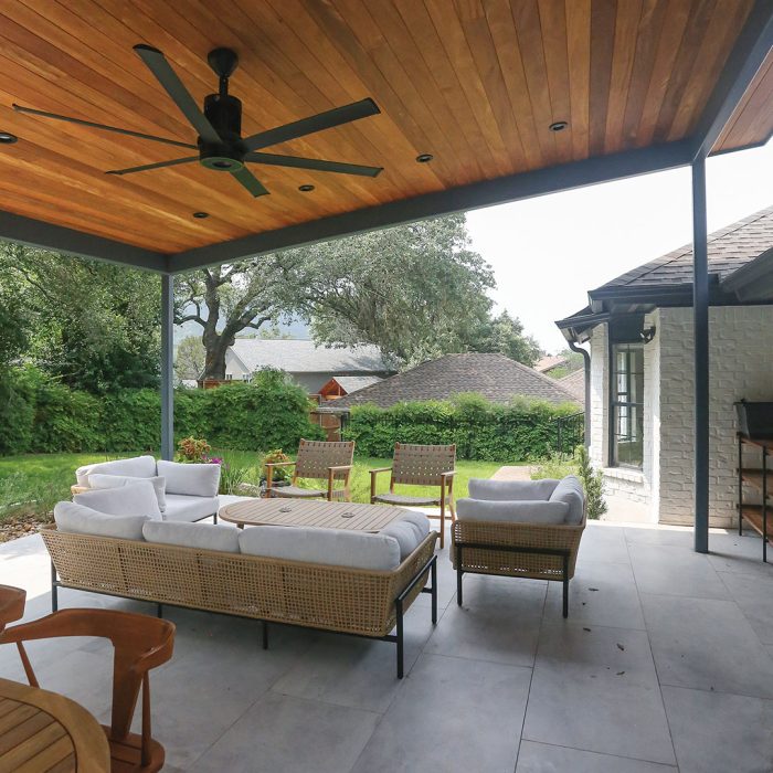 Photo of a white ranch-style home after renovation with an outdoor living space addition made of cumaru hardwood, metal, and more.